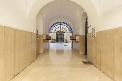 an empty hallway in a building with a large window at Hostly-Urban Oasis Turati-Few Steps from Colosseum in Rome