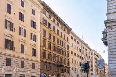 a large building on a city street with a traffic light at Hostly-Urban Oasis Turati-Few Steps from Colosseum in Rome