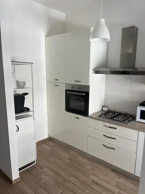 a kitchen with white cabinets and a stove at LoveRhome Apartment 10 in Rome