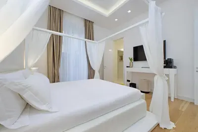 a white bedroom with a white canopy bed at Domus Aurea Luxury Suites in Rome