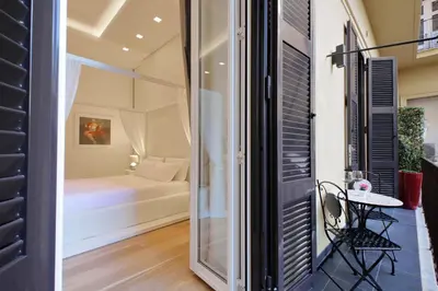 a room with a bed and a table and a window at Domus Aurea Luxury Suites in Rome