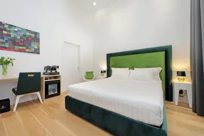 a bedroom with a large white bed and a desk at Domus Aurea Luxury Suites in Rome