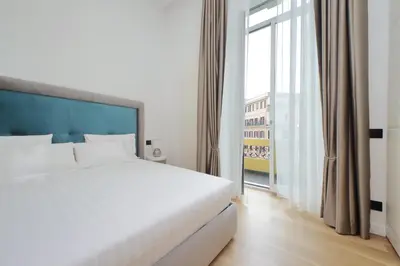 a bedroom with a white bed and a large window at Domus Aurea Luxury Suites in Rome