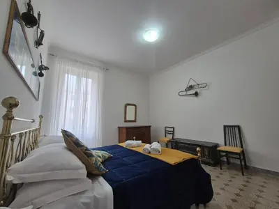 a bedroom with a bed with a blue comforter at Casa di Bea in Rome