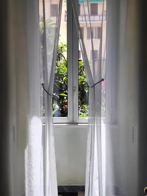a window with white curtains in a room at Iannilli Casa Vacanze in Rome
