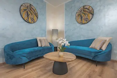 a living room with two blue couches and a table at Piazza del Popolo - The Heart of Rome in Rome