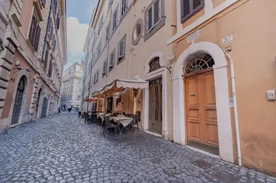 an empty street with tables and chairs in an alley at Piazza del Popolo - The Heart of Rome in Rome