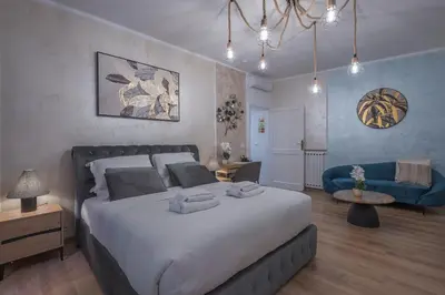 a bedroom with a large bed and a blue couch at Piazza del Popolo - The Heart of Rome in Rome