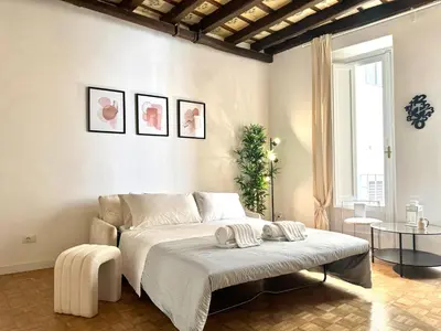 a white bedroom with a bed and a table at Luxury Apartment Historic Center in Rome