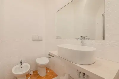 a white bathroom with a sink and a toilet at Cozy Rhome in Rome