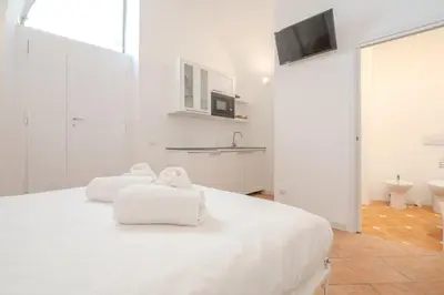a white bedroom with two towels on a bed at Cozy Rhome in Rome