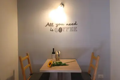 a table with two chairs and a bottle of wine at Ciambella Cozy Flat in Rome