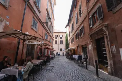 an alley with tables and umbrellas on a street at Ciambella Cozy Flat in Rome