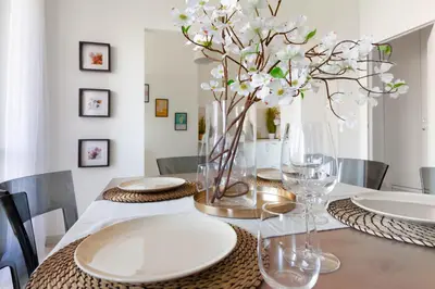 a dining room table with white plates and a vase of flowers at Balduina Retreat Terrace in Rome