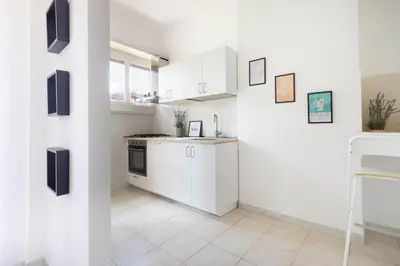 a white kitchen with white cabinets and a stove at Balduina Retreat Terrace in Rome