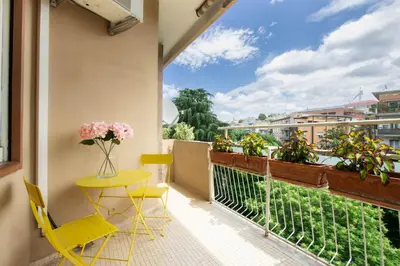 a balcony with a yellow table and chairs and a window at Balduina Retreat Terrace in Rome