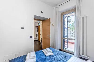 a bedroom with a blue bed and a window at Vatican Bridge Home in Rome