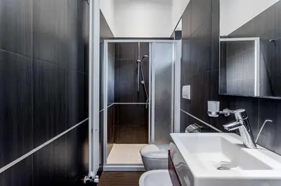 a bathroom with a shower and a toilet and a sink at Vatican Bridge Home in Rome