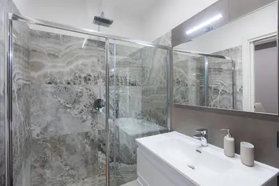 a bathroom with a shower and a sink and a mirror at Luxury Suite Coronari in Rome