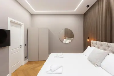 a bedroom with a white bed and a mirror at Luxury Suite Coronari in Rome
