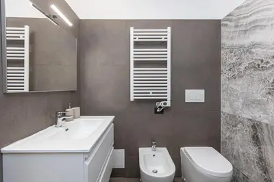 a bathroom with a sink and a toilet and a mirror at Luxury Suite Coronari in Rome