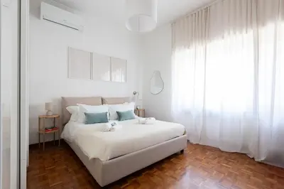 a white bedroom with a bed with two stuffed animals on it at Domus La Conca in Rome