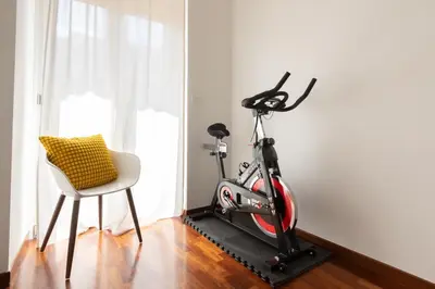 a bike on a treadmill next to a chair in a room at Domus La Conca in Rome