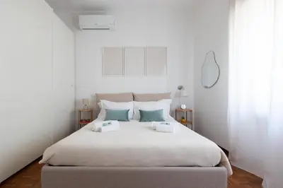 a bedroom with a large white bed with two pillows at Domus La Conca in Rome