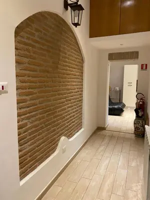 a brick wall in a hallway with a tile floor at B&B trastevere il vicolo in Rome