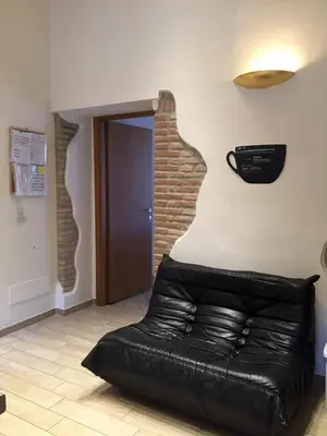 a black leather couch in a room with a door at B&B trastevere il vicolo in Rome