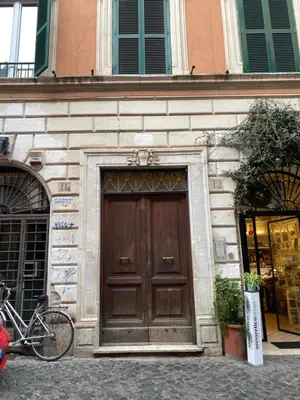 a building with a wooden door with a bike parked in front at B&B trastevere il vicolo in Rome