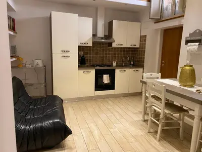 a kitchen with white cabinets and a table and chairs at B&B trastevere il vicolo in Rome