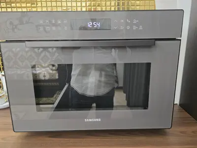 a microwave oven with a persons reflection in the window at The Etrurian Rapsody in Rome