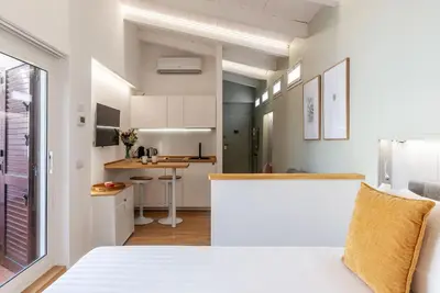 a kitchen and a living room with white cabinets at Rasella 21 - FromHometoRome in Rome