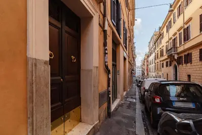 a narrow street with cars parked on the side of a building at Rasella 21 - FromHometoRome in Rome