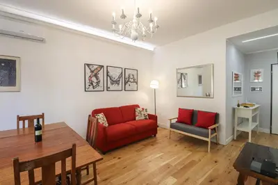 a living room with a red couch and a table at Casilina 403 Spacious Apartment 3BDR and 3 BATH in Rome