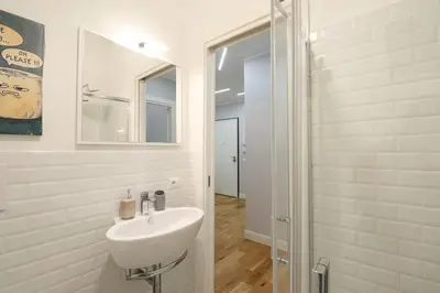 a white bathroom with a sink and a shower at Casilina 403 Spacious Apartment 3BDR and 3 BATH in Rome