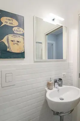 a white bathroom with a sink and a mirror at Casilina 403 Spacious Apartment 3BDR and 3 BATH in Rome