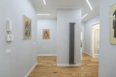 a room with white walls and a hallway with paintings at Casilina 403 Spacious Apartment 3BDR and 3 BATH in Rome