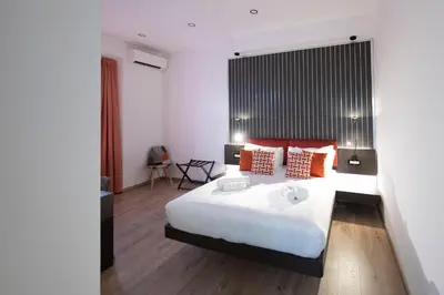 a bedroom with a large white bed with orange pillows at Trastevere New Luxury Rooms in Rome