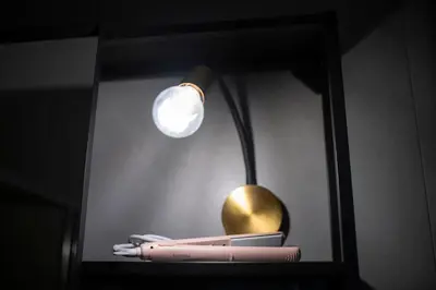 a lamp in a black shelf with someones belongings at Trastevere New Luxury Rooms in Rome