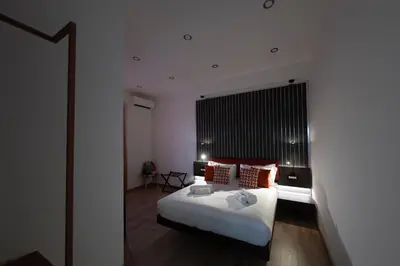 a bedroom with a large white bed with red pillows at Trastevere New Luxury Rooms in Rome