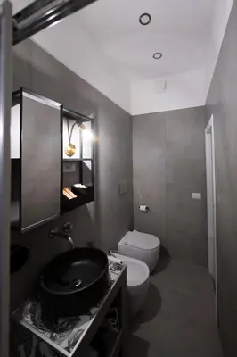 a bathroom with a black sink and a toilet at Trastevere New Luxury Rooms in Rome