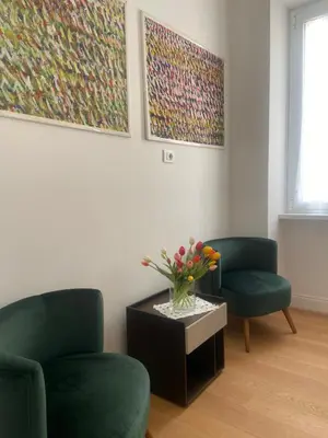 a living room with two chairs and a table with flowers on it at Appartamento Villa Ada in Rome