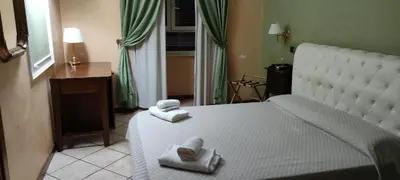a bedroom with a white bed with towels on it at Hotel MontReal in Rome
