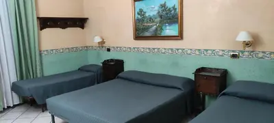 a room with three beds and a picture on the wall at Hotel MontReal in Rome