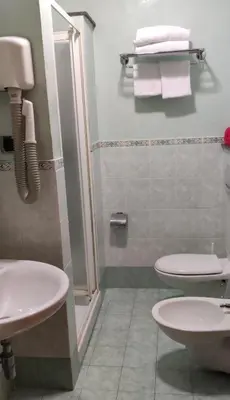 a bathroom with two toilets and a shower with towels at Hotel MontReal in Rome