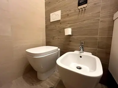 a bathroom with a white toilet and a sink at Oasi Floreale - Roma Termini in Rome