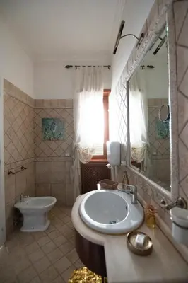 a bathroom with a sink and a toilet and a mirror at Interno 6 in Rome