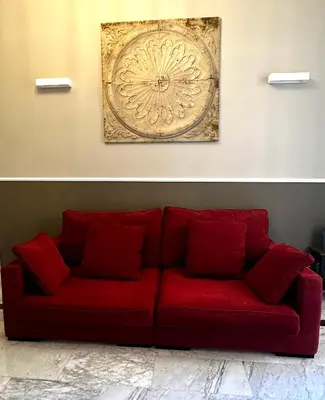 a red couch in a living room with a painting on the wall at Via Veneto Luxury Maison in Rome